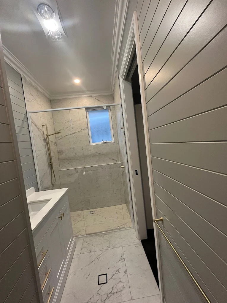 Marble-tiled shower and vanity